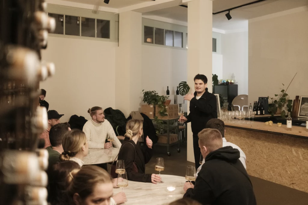 Junus spricht vor Gruppe auf Vinum Voyage Weinevent