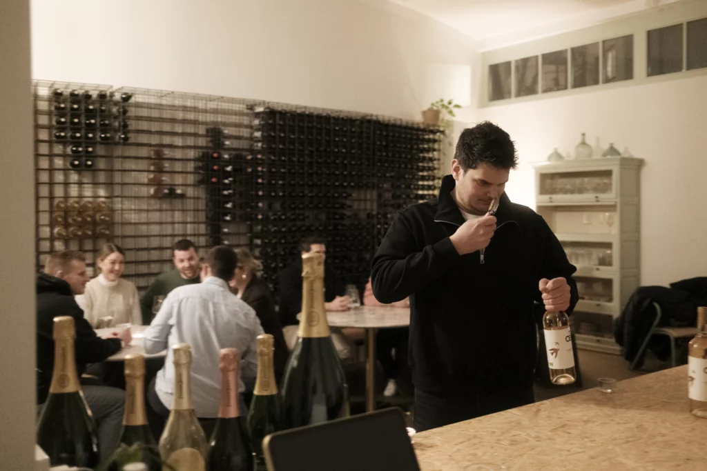 Junus öffnet eine Flasche bei einem Vinum Voyage Weinevent